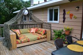 łóżko wykonane z palet stojące w ogrodzie